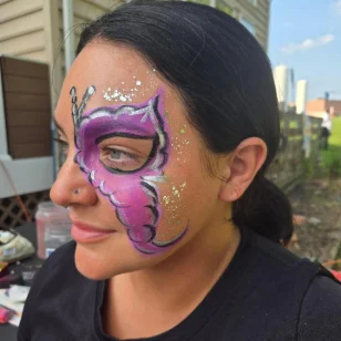A woman with a magenta butterfly facepainting