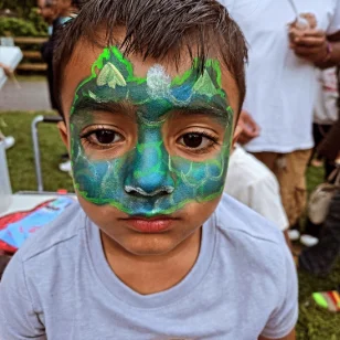 A boy with a dinosaur facepainting