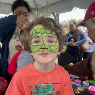 A young boy with a green facepainting
