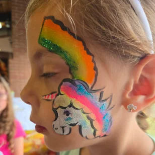 A girl with a rainbow and unicorn facepainting
