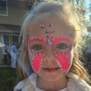 A girl with a pink butterfly facepainting